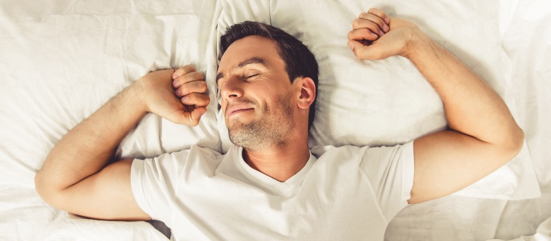 Man with sleep apnea wakes up refreshed after improving his sleep with Dental Sleep Medicine