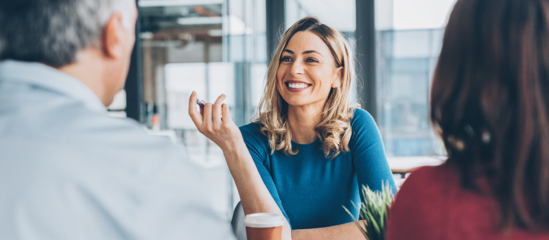 Business woman smiles at work to boost her productivity and improve her mood