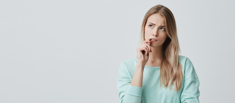 Blonde woman pulls her lip as she worries about feeling pain during root canal therapy in Liberty, MO