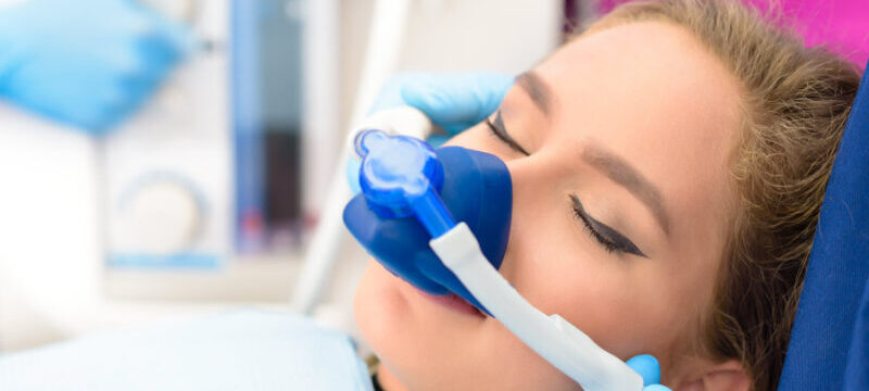 Closeup of a young woman wearing a nose mask so she can breathe in relaxing nitrous oxide