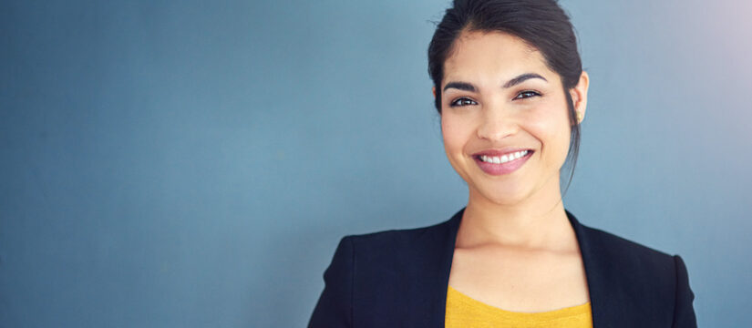 Business woman in a yellow blouse smiles after teeth whitening