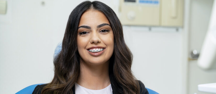 Brunette woman wearing braces to correct crooked teeth and improve her oral health